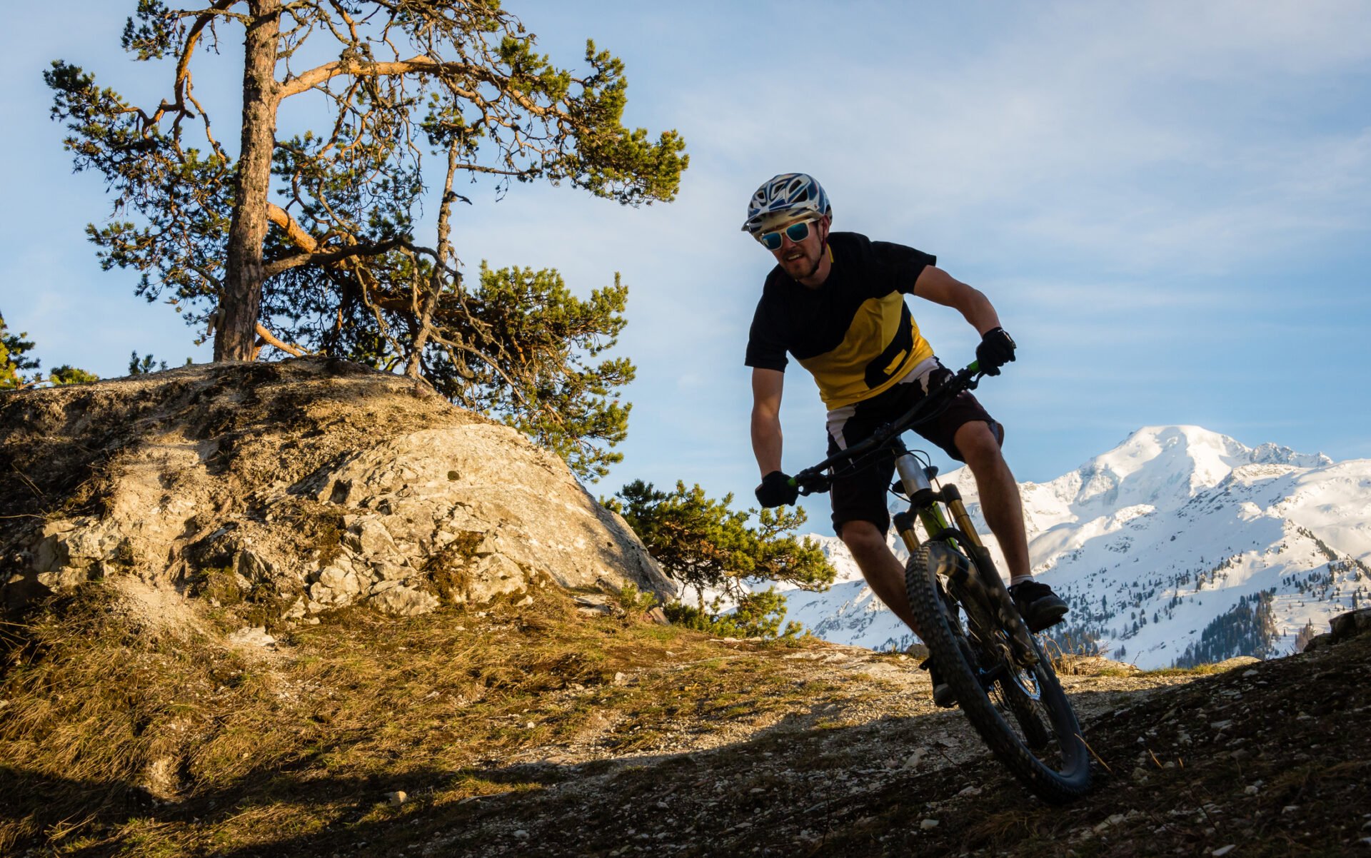A mountain biker riding in the French Alps with a spectacular backdrop.