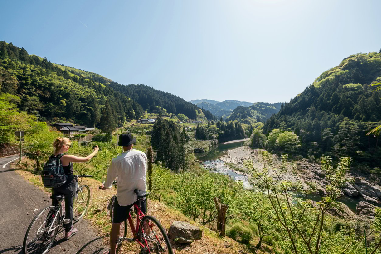 Young couple taking a photo while cycling in the mountains