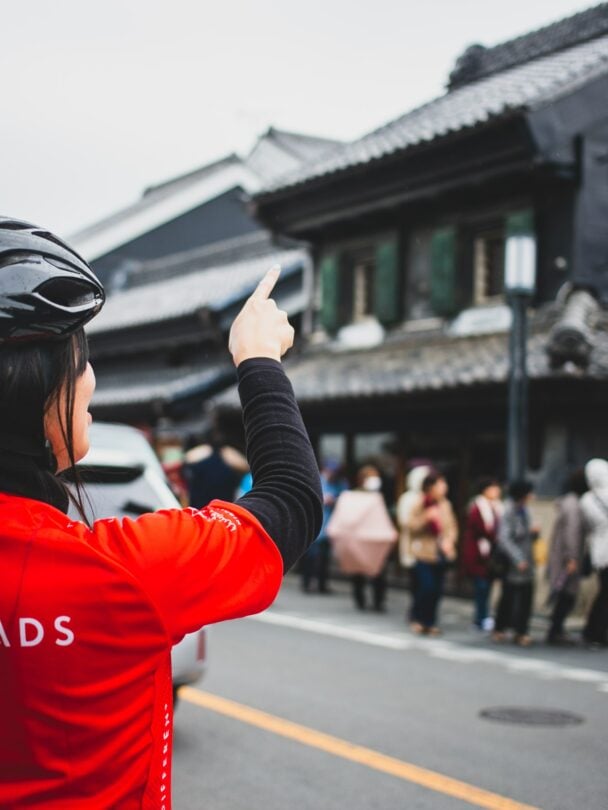 A bike rider pointing at an old building in Kyoto, Japan