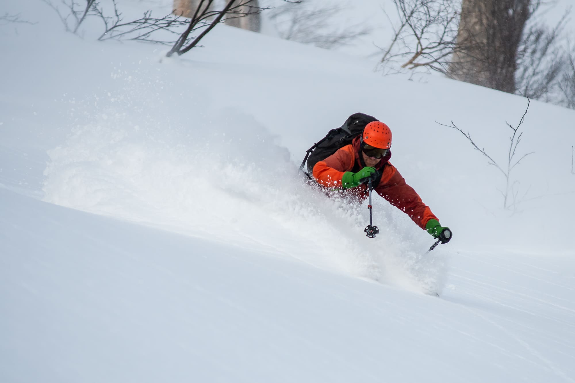 Skier going downhill and shredding snow in Japan